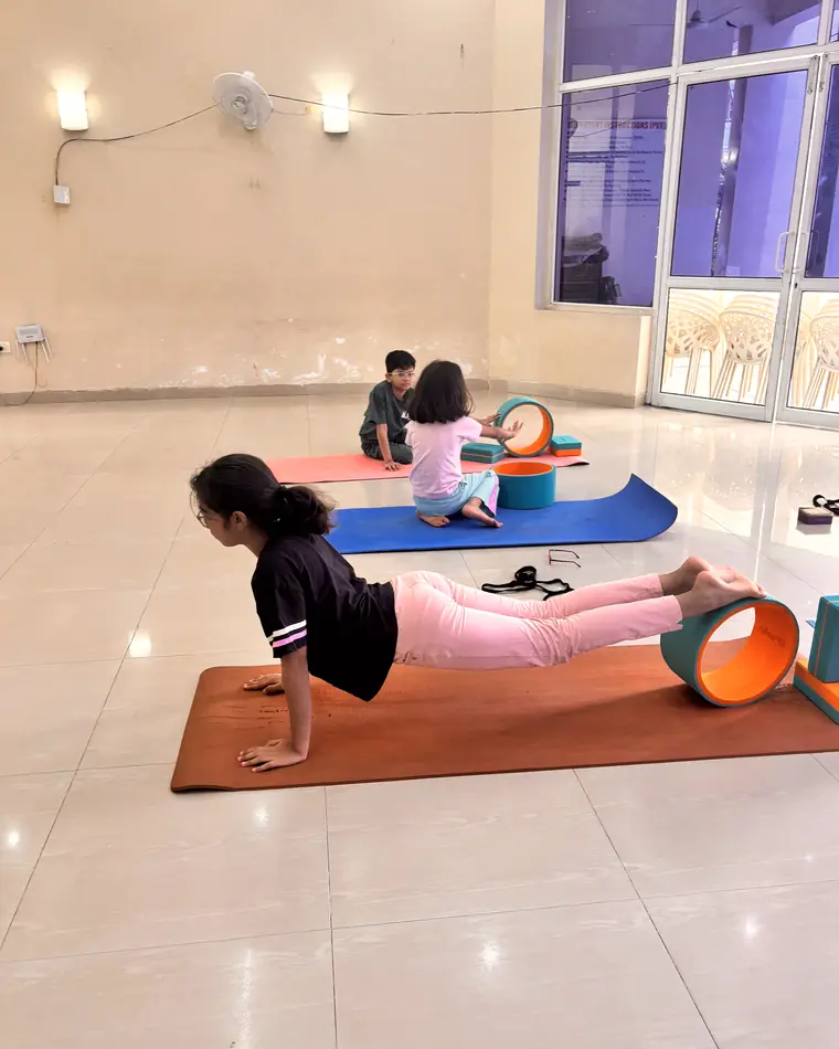Children practising yoga with props in a kids class