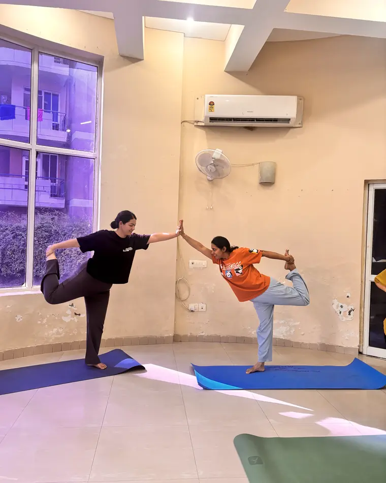 Two students holding a standing balance together