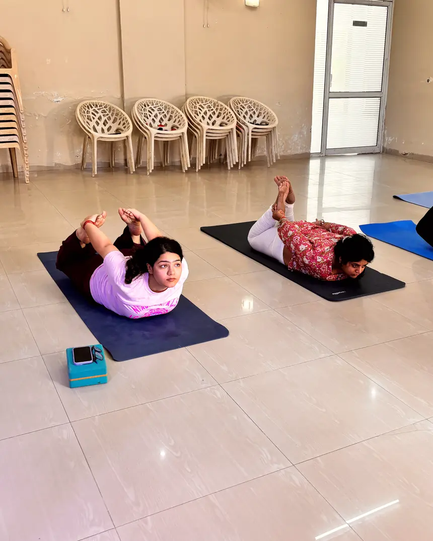 A group class practising dhanurasana together at the Living Yog studio in Gurugram